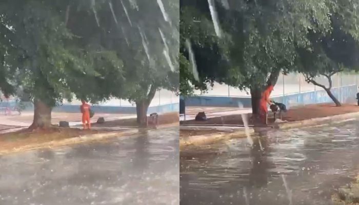 Trabalhador é filmado recolhendo lixo durante temporal, em Anápolis